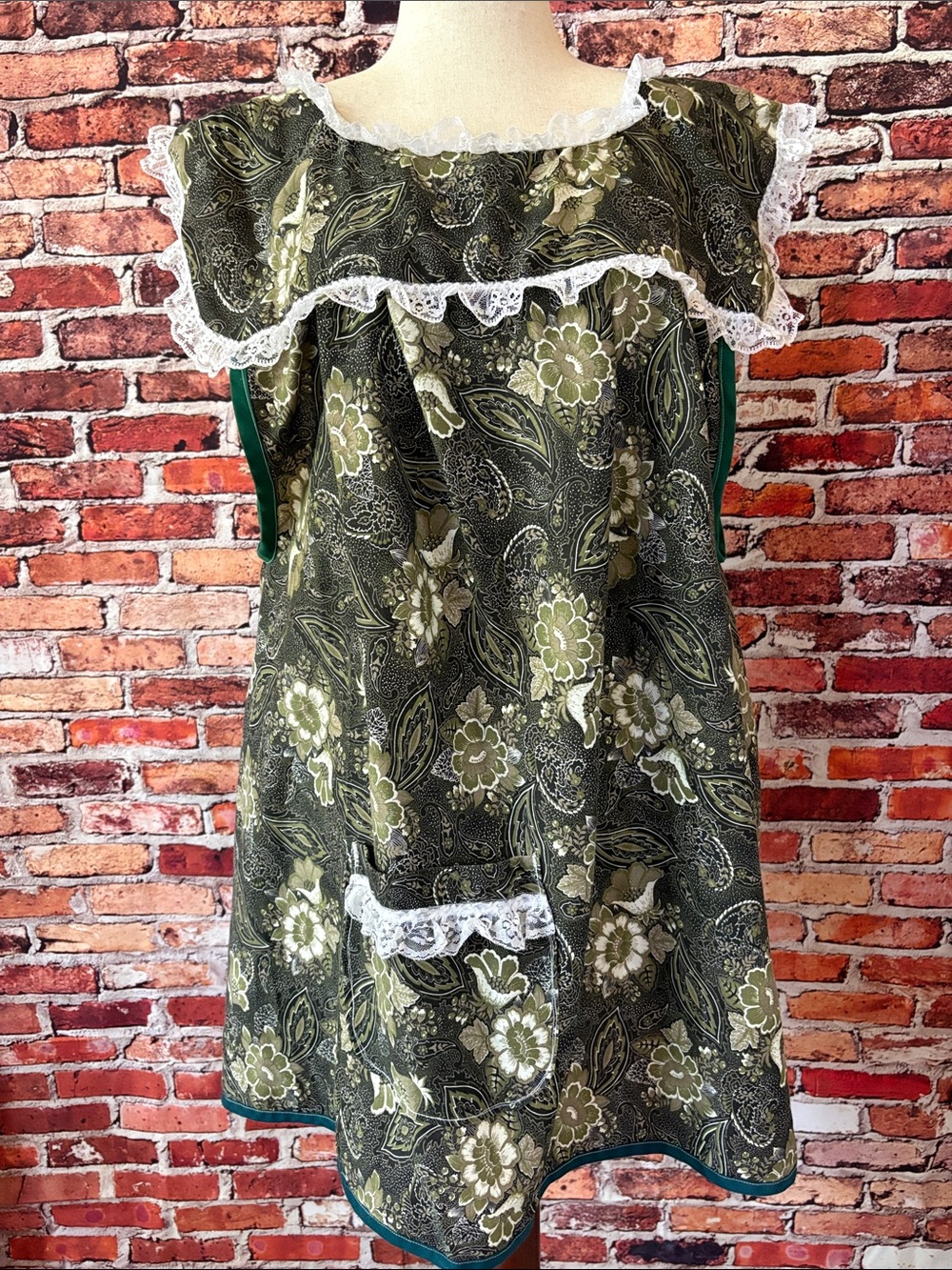 Green floral apron pinafore with white lace trim and a front pocket One Size